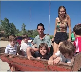 Niños y monitores del campamento subidos a un carro