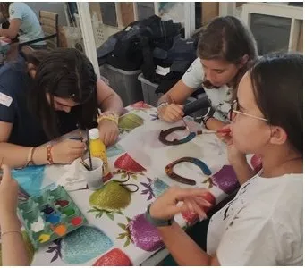 Niñas pintando herraduras en el taller de manualidades