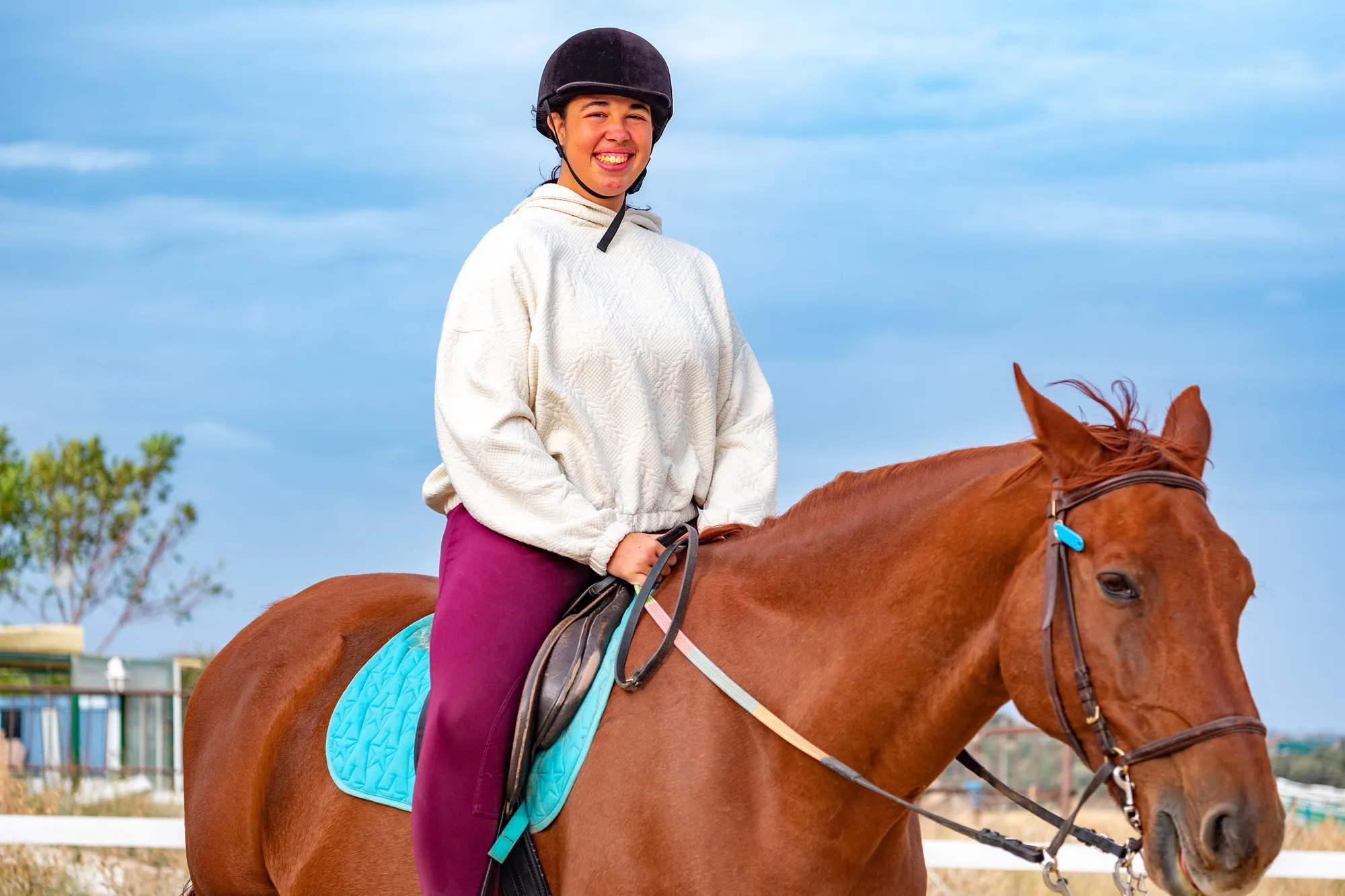Una amazona sonríe a caballo durante una sesión de equitación terapéutica