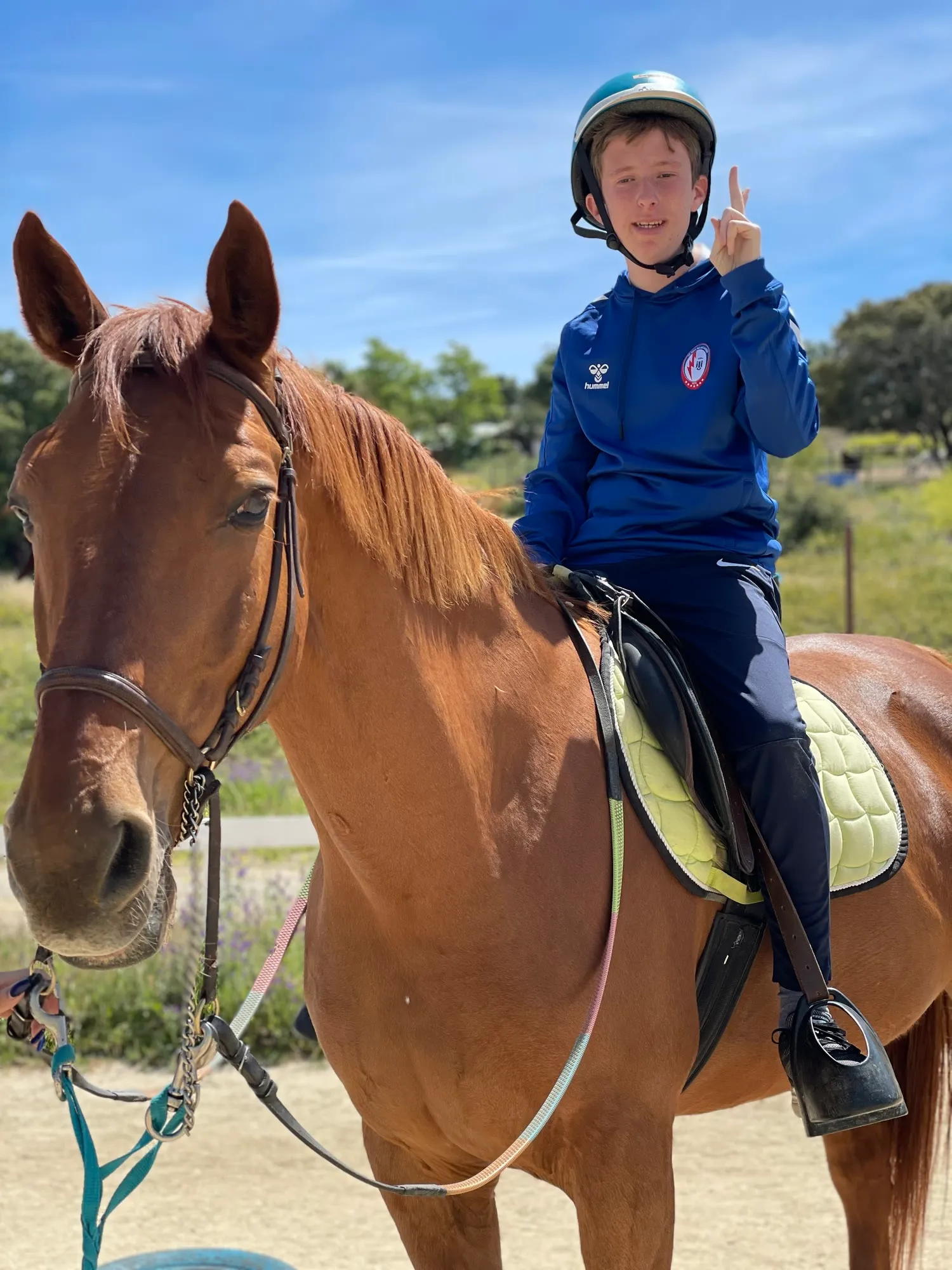 Sesión de equitación terapéutica: un niño monta y dirige él mismo al caballo