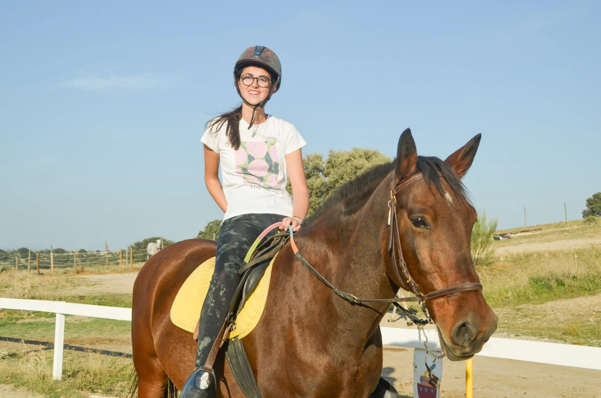 Sesión de equitación terapéutica con la terapeuta a pie junto al caballo