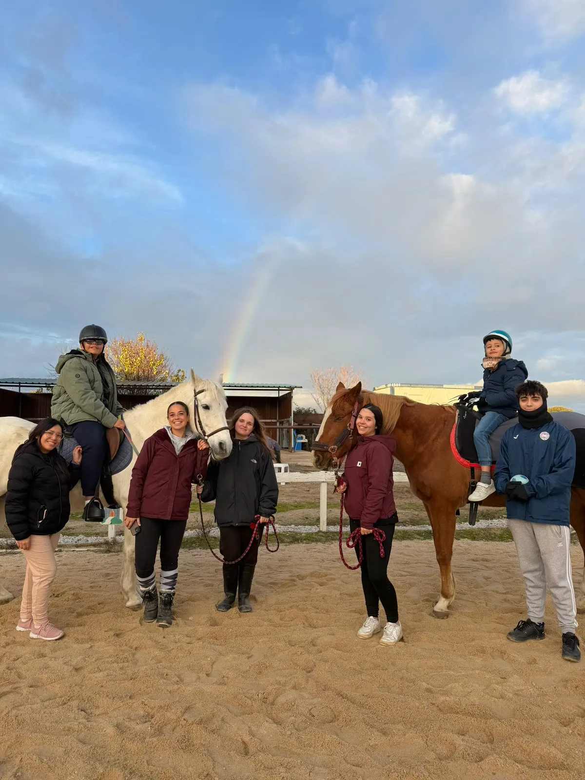 Jornada de ocio de Al Paso: el grupo posa con los caballos bajo un arcoíris