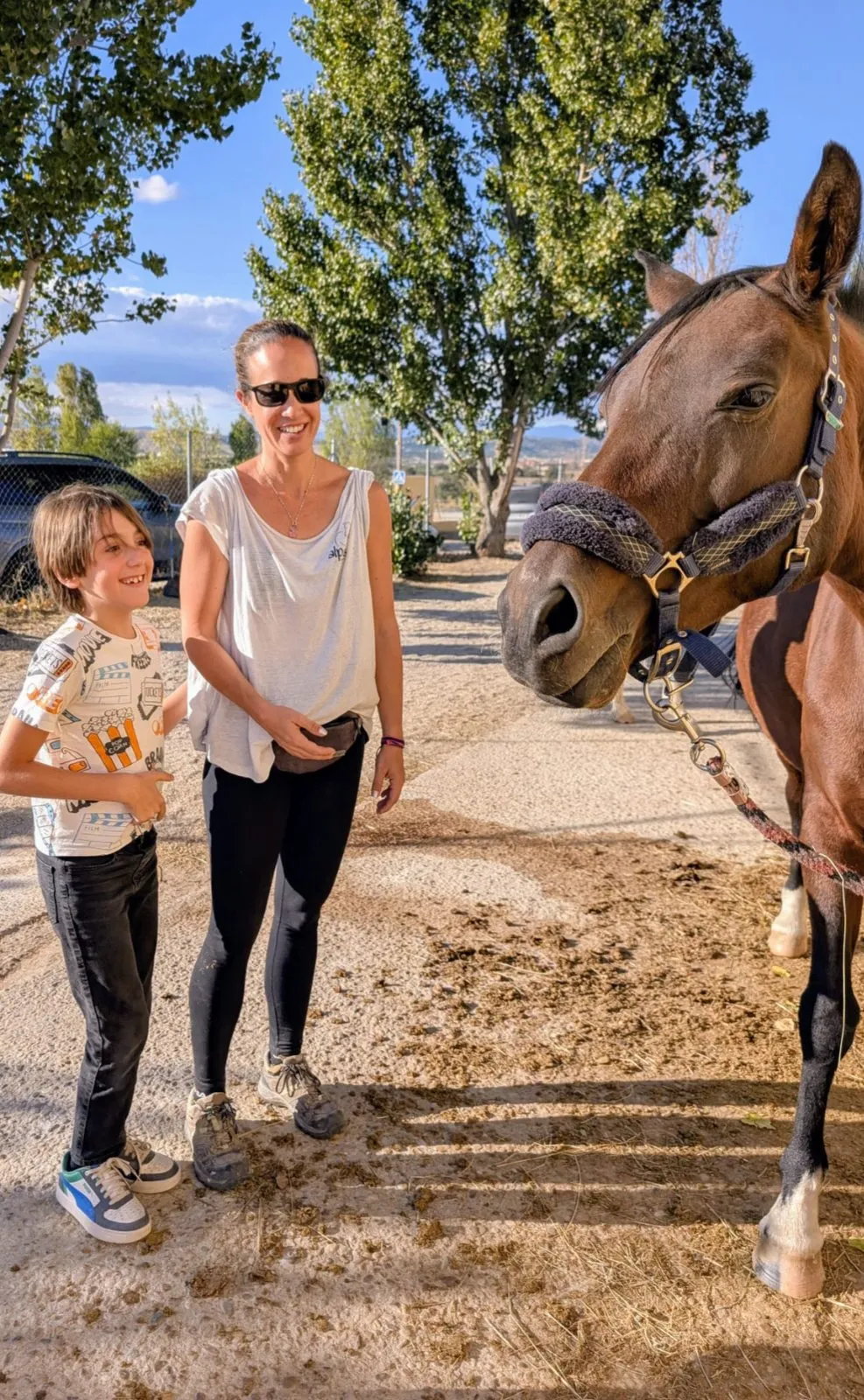 Una monitora y un niño junto a uno de los caballos