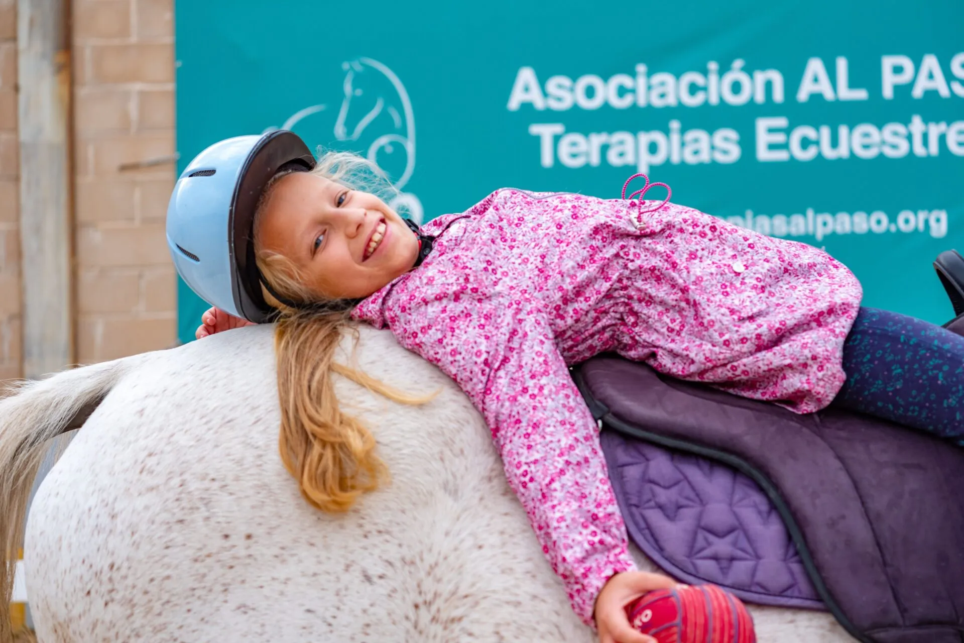 Niña tumbada sobre el caballo durante una sesión