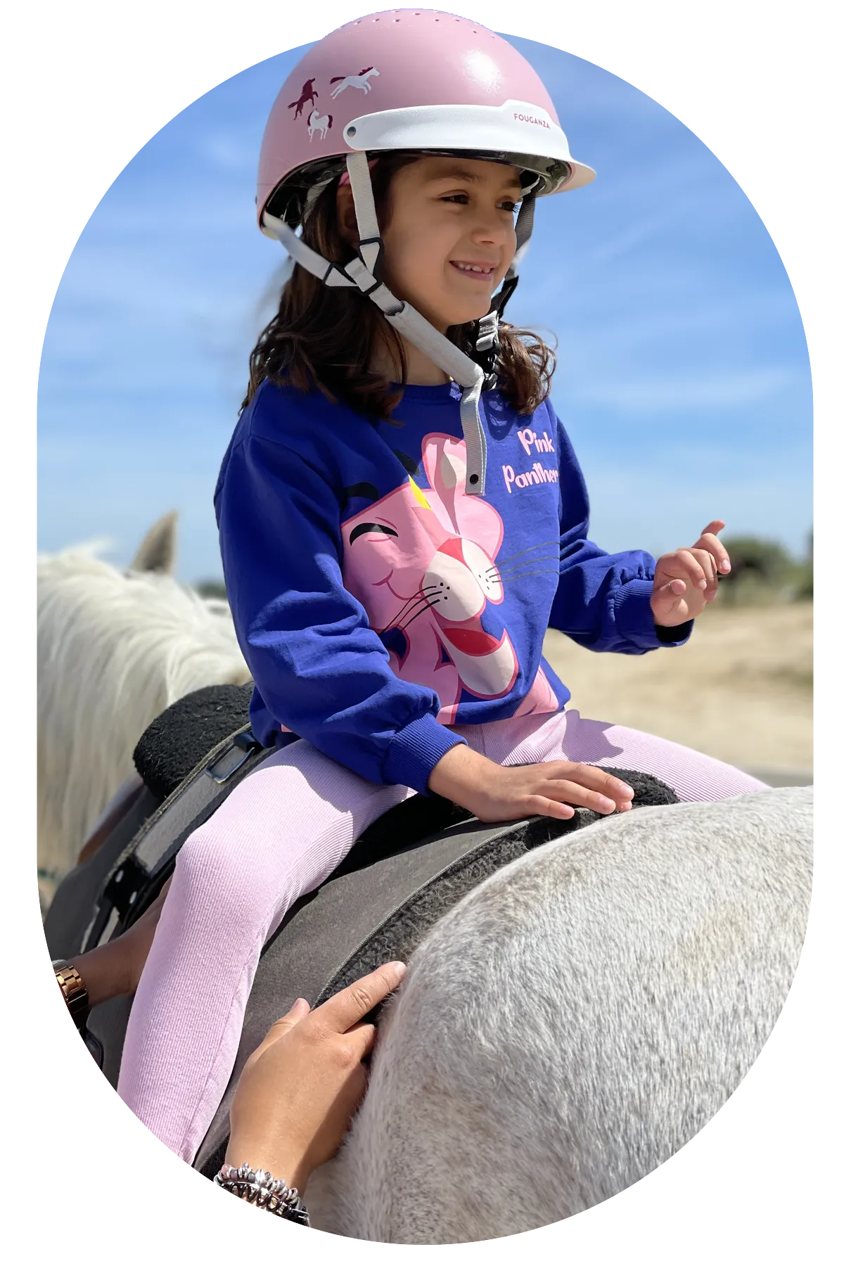 Una voluntaria de Al Paso acompaña a una niña durante su sesión a caballo
