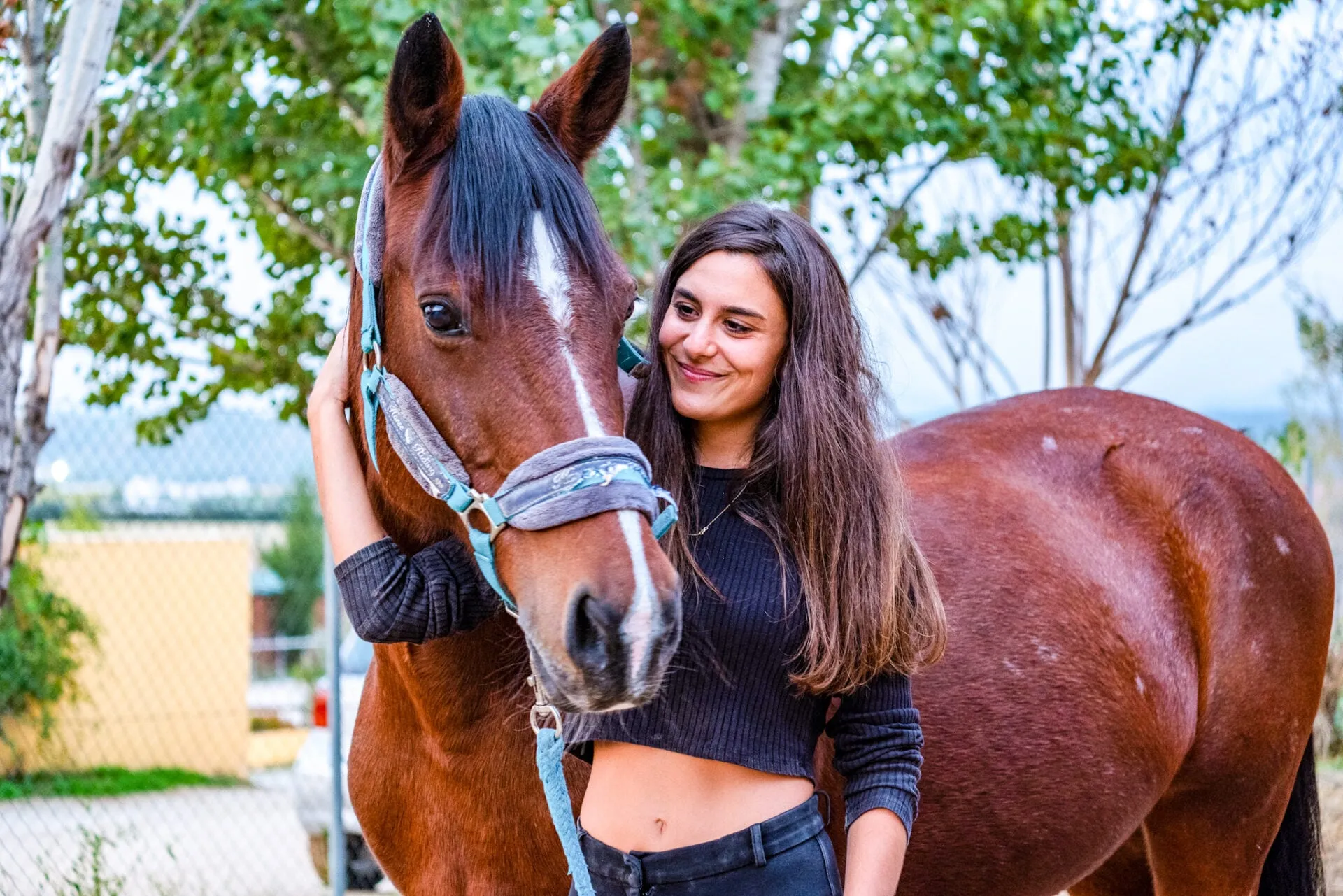 Una voluntaria abraza a uno de los caballos de terapia